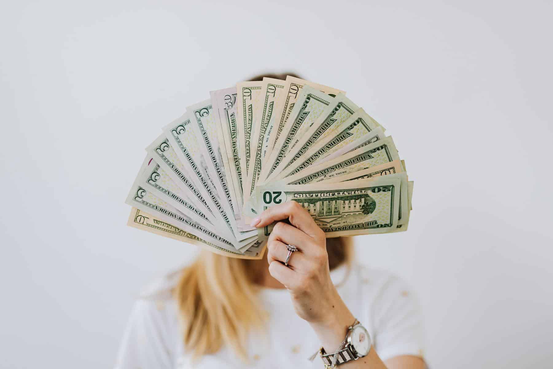 Woman holding stack of money