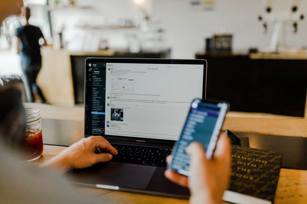 Man using a cellphone and a laptop