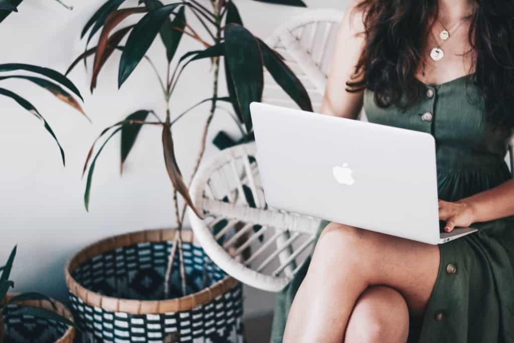 girl in green dress using macbook