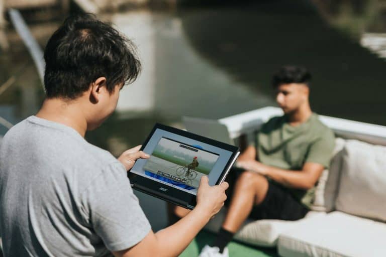 man in gray crew neck t-shirt and gray pants sitting on white bed using black windows 11 settings mac address, network settings, find mac address