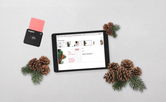 a tablet computer sitting on top of a table next to pine cones woocommerce email customizer, drag and drop, store design