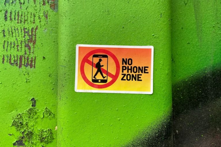A no phone zone sign on a green wall smartphone warning snapchat error