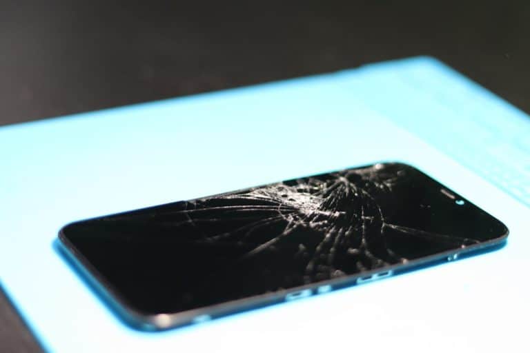 Broken smartphone screen on a blue mat. smartphone warning snapchat error