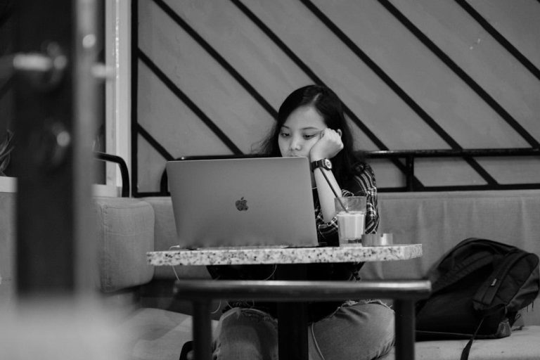 a person sitting at a table with a laptop vpn devices, people troubleshooting, happy user