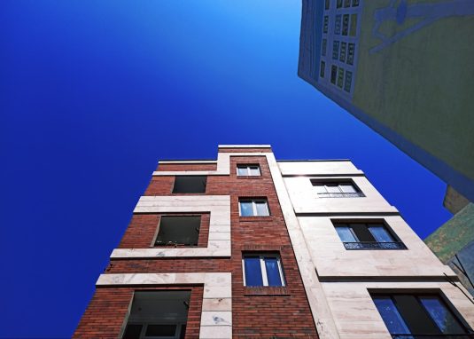 looking up at a tall brick building with windows property manager, apartment building, accounting software