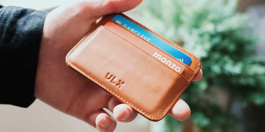 person holding brown ULX leather wallet happy customer, secure crypto wallet, digital payments
