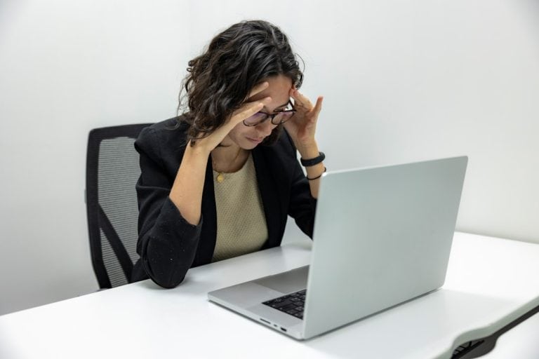 a woman sitting in front of a laptop computer frustrated customer, chatbot failure, unhappy client