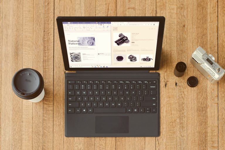 black Surface device on brown wooden table shopify dashboard laptop interface