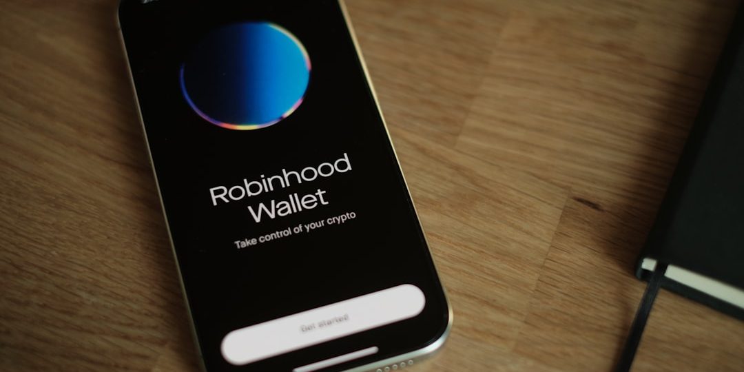 A cell phone sitting on top of a wooden table robinhood app, mobile wallet, crypto transfer