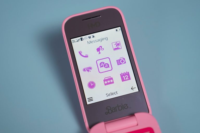 A pink cell phone sitting on top of a table pinterest app screenshot, download image, mobile phone interface