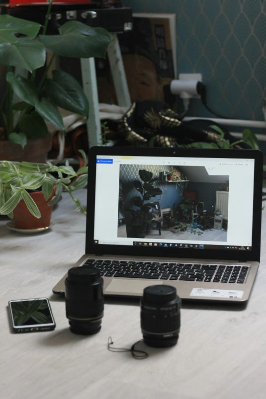 macbook air on white table multiple video apps open screen task manager webcam