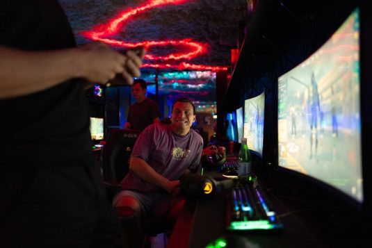 People playing video games in a dimly lit room. gaming pve boss fight fantasy