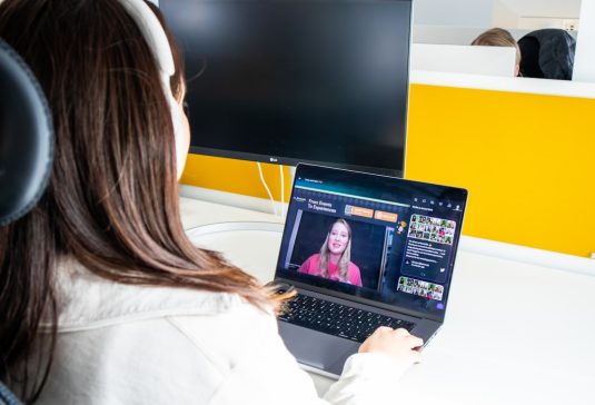a woman sitting in front of a laptop computer virtual coworking, video conference, entrepreneur meetup