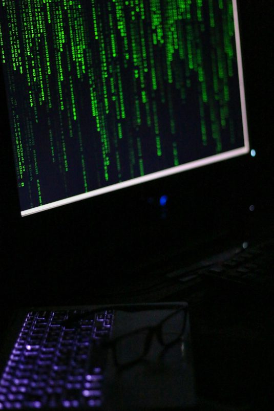 A computer monitor sitting on top of a desk mystery code computer dark web