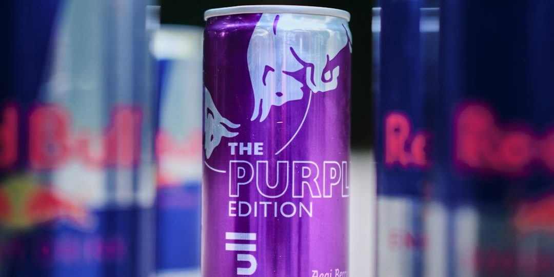 a group of cans of beer sitting on top of a table energy drinks shelf flavors monster redbull